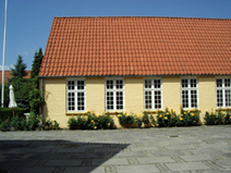デンマークの伝統的なレンガづくりの家。太陽の光をいっぱいに浴びて咲くバラ。