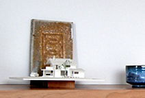 玄関の飾り棚にはモデルハウスの模型と、「輪違い紋」を型どった陶板。