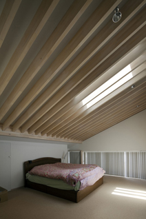 寝室の温熱環境は良好。Low-E ガラスの天窓のほか、総厚約18cm の中に合板・断熱材・空気層など多様な素材を納めた屋根が、デザインと快適性を両立させた。