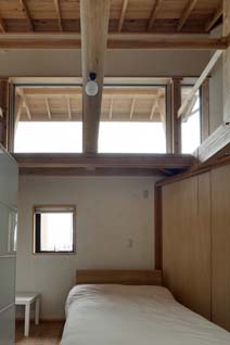 天井を張っていない寝室からは小屋組も高窓も一望できる。ベッドサイドには、浅野邸でほぼ唯一といえる収納が設けられた。