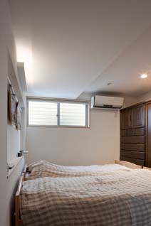 プライバシー確保のため高い位置に窓を設けた寝室。各室にエアコンが設置されているが「とくに１階は夏は涼しく、冬も寒くない」と住まい手は口を揃え、断熱性能の高さがうかがえる