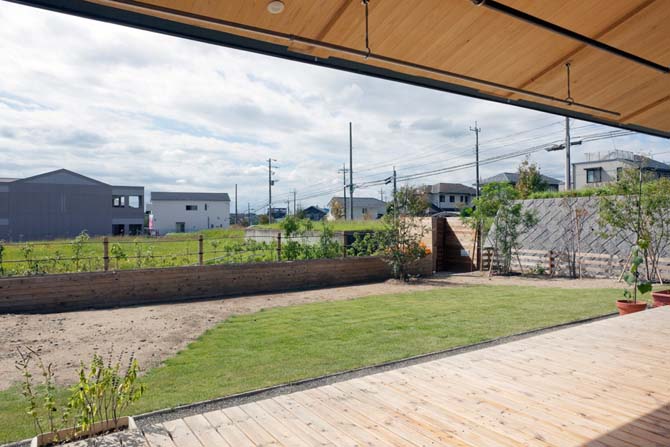 発展途上のY邸の外構は、芝生や植栽、門までYさんが自らつくってきた。低い塀の向こうには遊歩道が走り、周囲の住宅からの視線も考え合わせて樹木による目隠しをこれから考えていくとのこと。大きな窓越しに家じゅうどこからでも見渡せる庭は、テラスという心地よい中間領域を経て、ごく自然に室内とつながっている