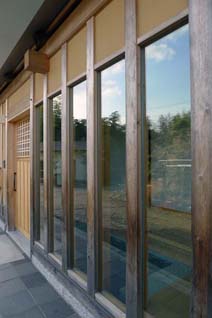 南に面したファサードでは、既存材を利用した窓枠にエコガラスがはめ込まれた。防音用として5ミリ厚のガラスを採用し、騒音と日射熱を遮る。サッシを使わないことで伝統的な和の家の雰囲気を保っている。